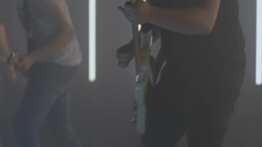 The band is performing on the dark stage