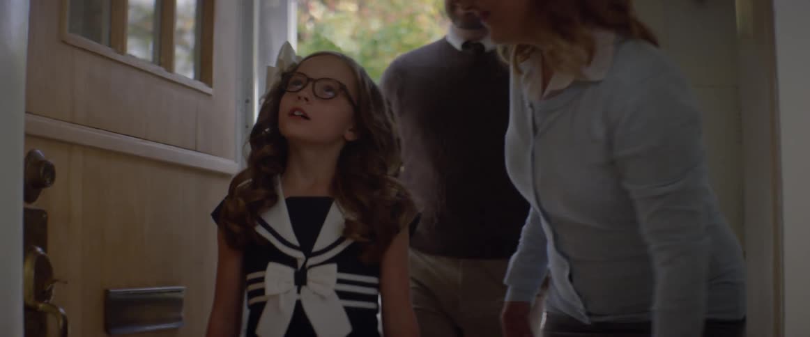 A couple and young girl enter the front door