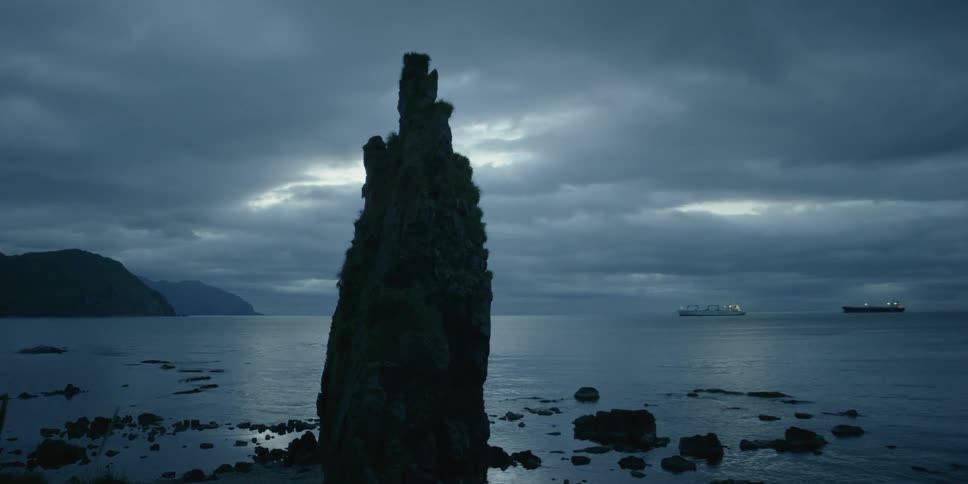 A tall rock tower in the water