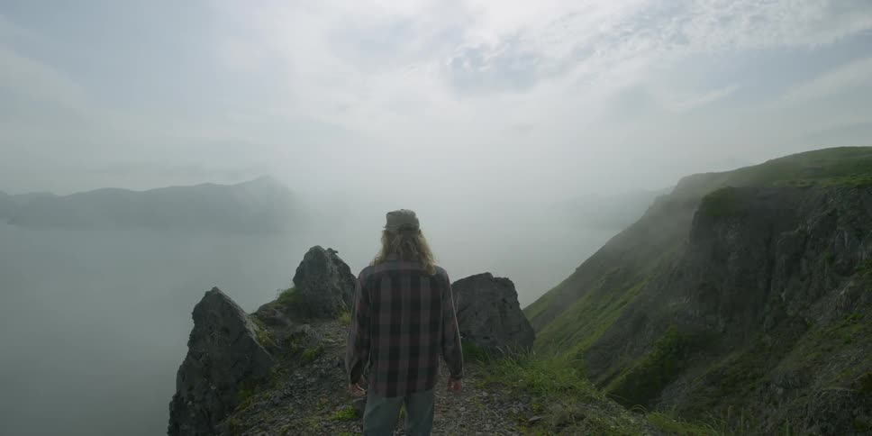 A man walks on the edge of a cliff