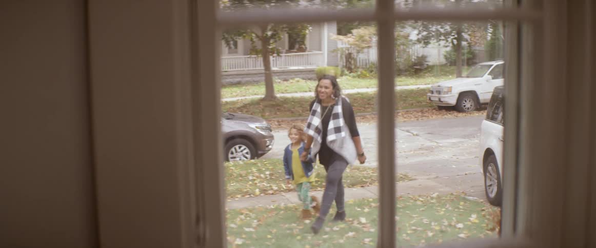 A woman walks her child to the house