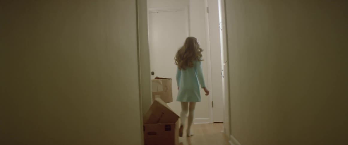 A girl runs through a hallway in a house during the day