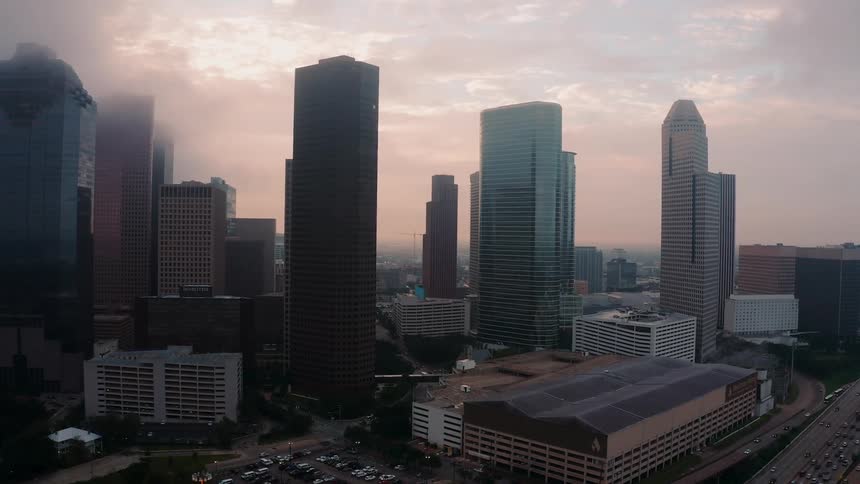 The clouds touch the top of the city buildings