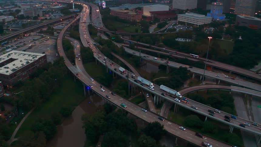 Vehicles travel on highway roads at dusk