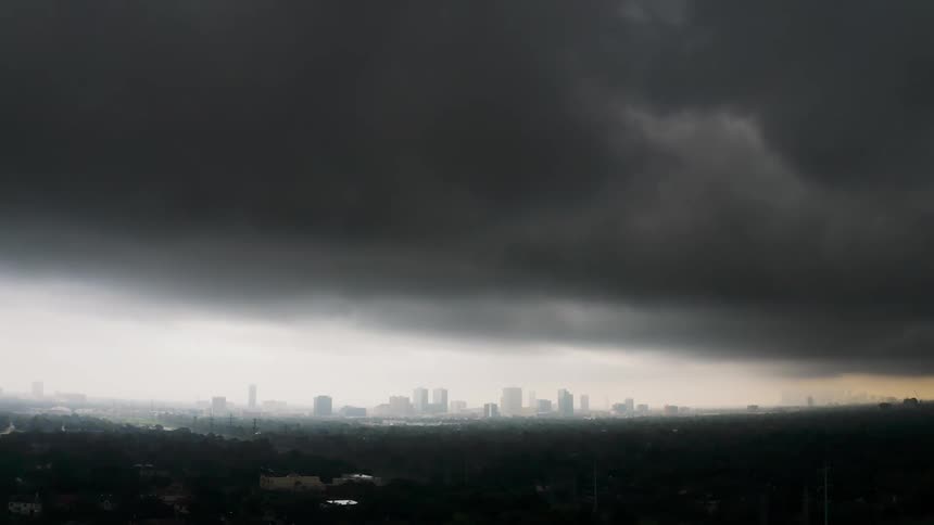 Storm clouds are drifting towards a city during the day