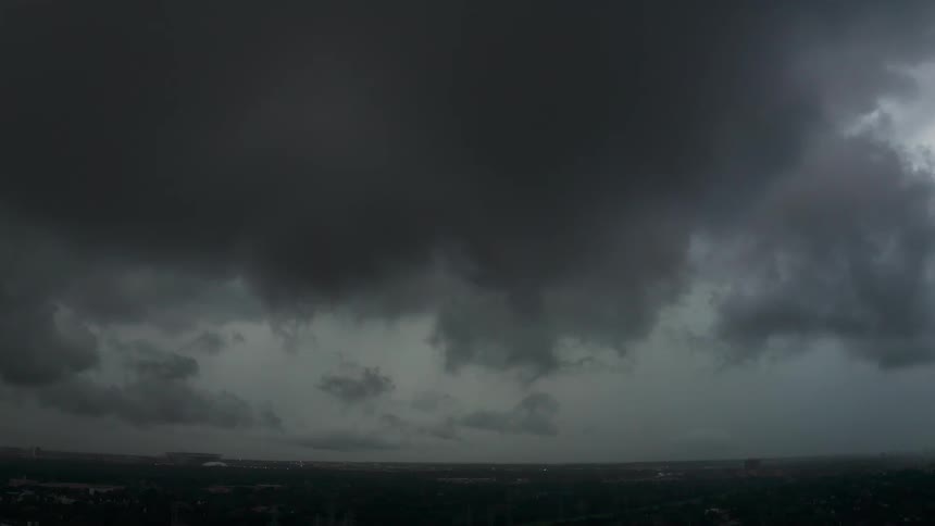 Storm clouds hang over a valley at dusk