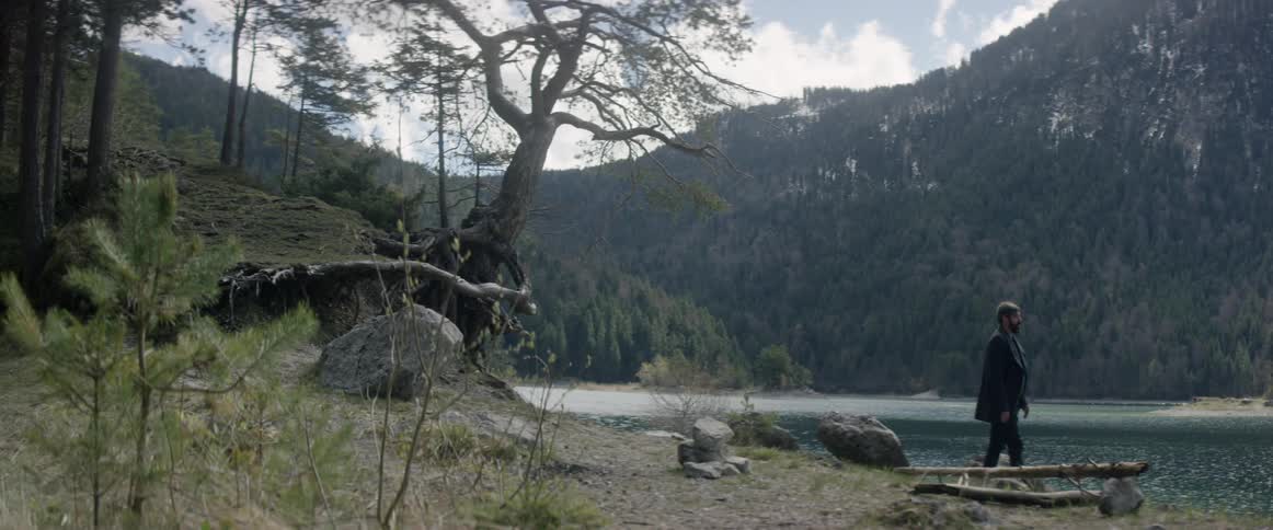 A man stands up and walks towards the water