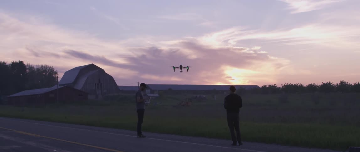 A man flying a drone in the middle of the road