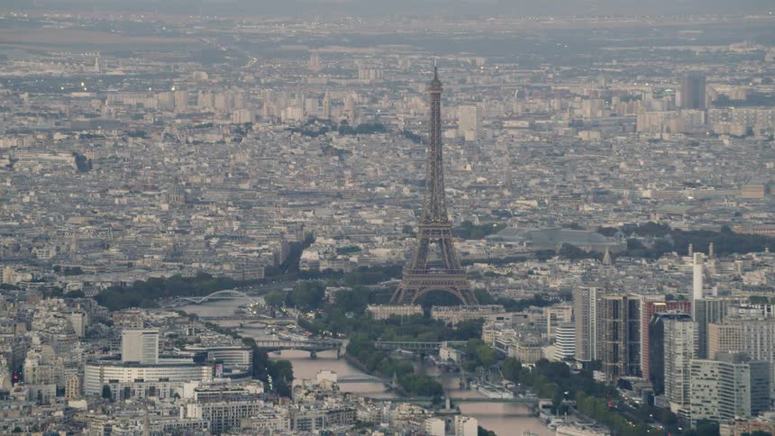 The eiffel tower dominates the skyline in a city on a smoggy day
