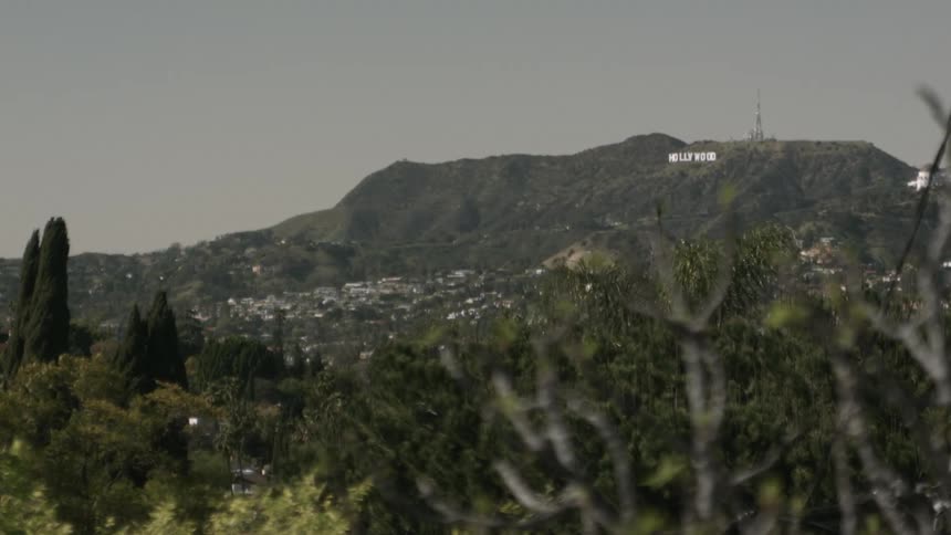 A sign on a mountain overlooking a city