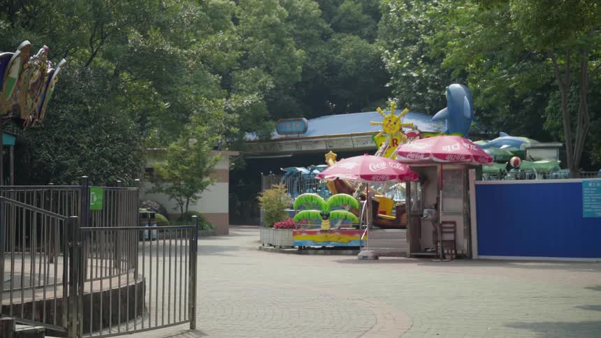The wind is blowing the ruffles on umbrellas in an empty amusement park during the day