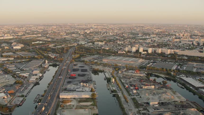A bridge stretches across a city canal entering the city