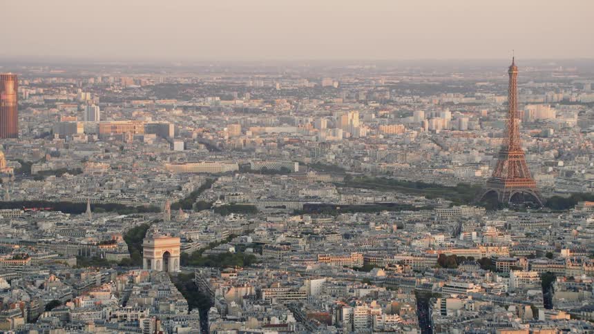 The eiffel tower stands tall above the other city buildings near the canal