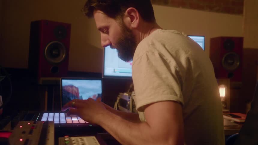 A man is making music on a midi pad