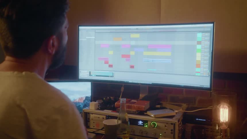 A musician records in a studio with electronic equipment