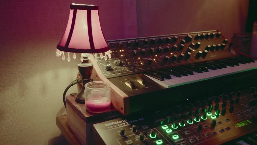 A lamp and candle on a table with a keyboard