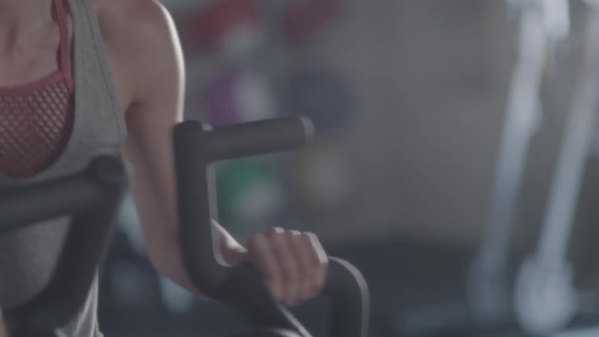 Woman works out on an exercise machine at a gym