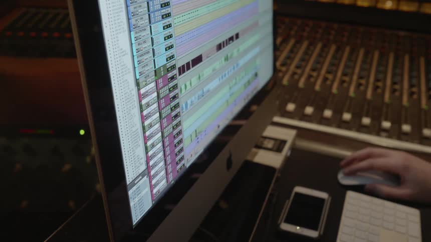 A musician edits a recording on a computer