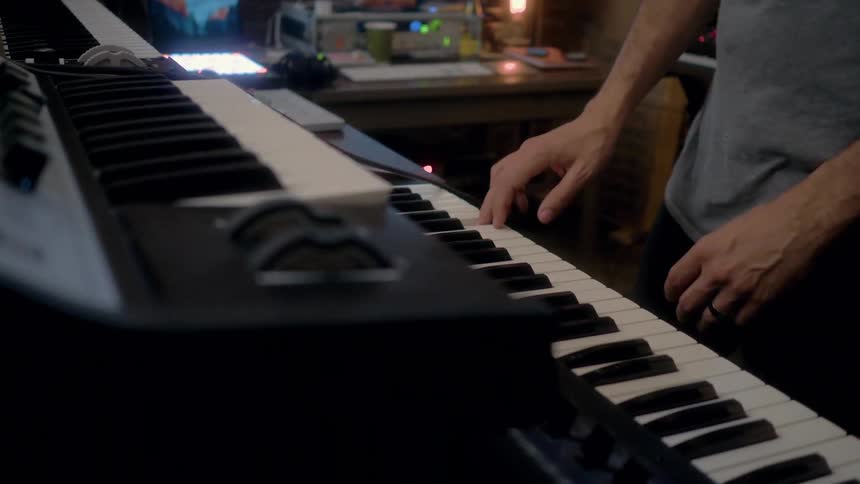 A musician records in a studio with electronic equipment