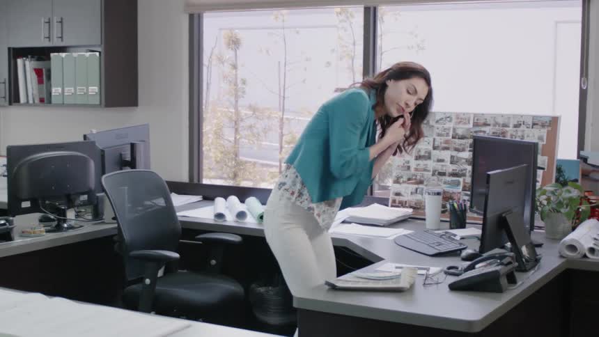 A woman is working in the office while talking on the phone