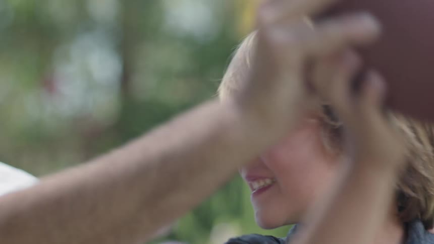 Father and son play with a football
