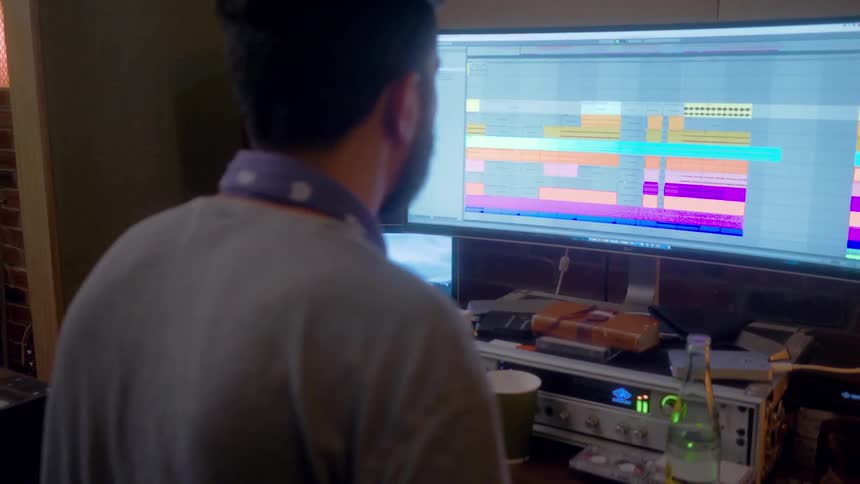 A musician edits a recording on a computer