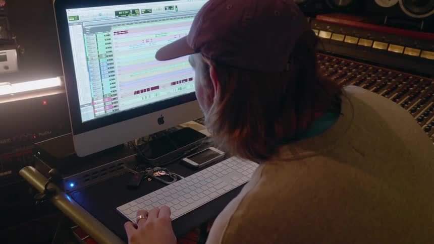 Man works at a computer in a recording studio