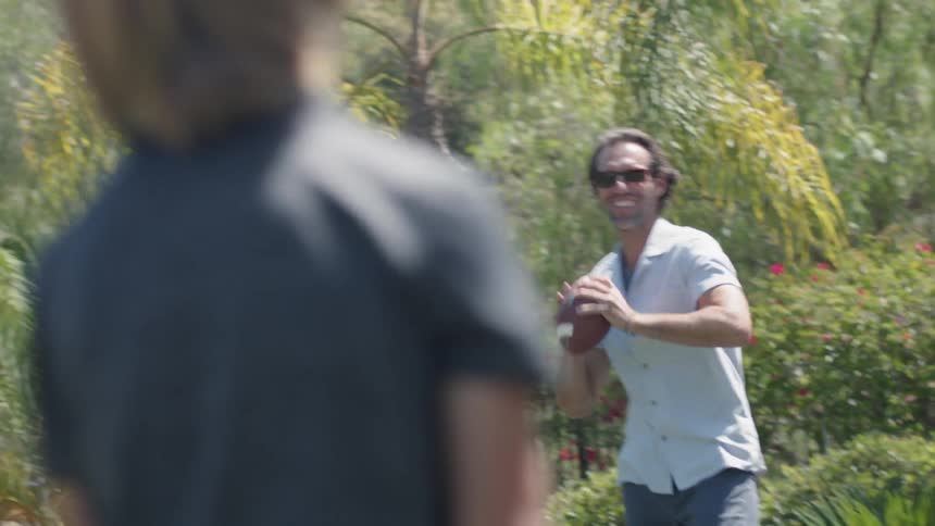 A man and boy play catch with a football