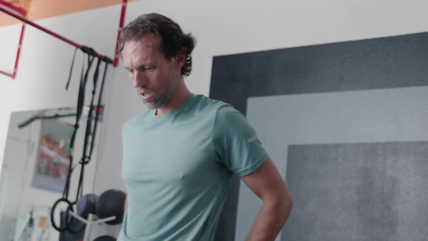 Man breathes heavily while exercising in a gym