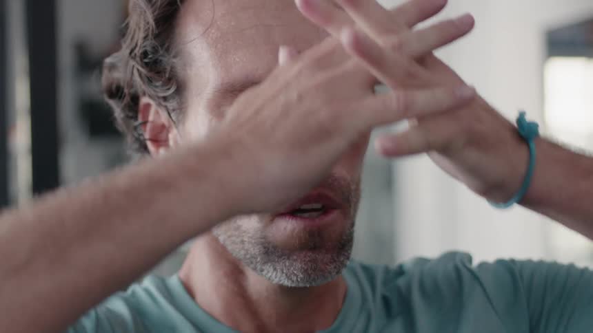 Man looking exhausted and concerned as he places his hands behind his head