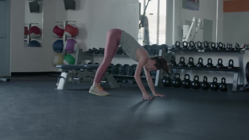 A woman stretches in a gym