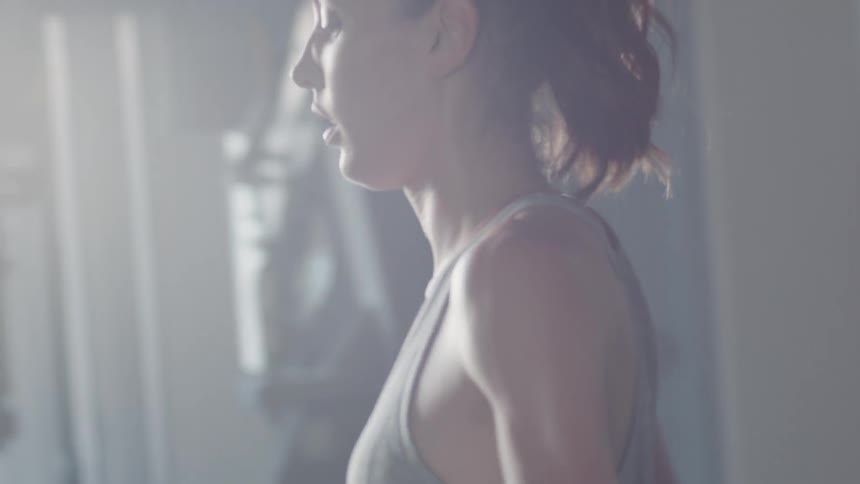 A woman catches her breath in a gym