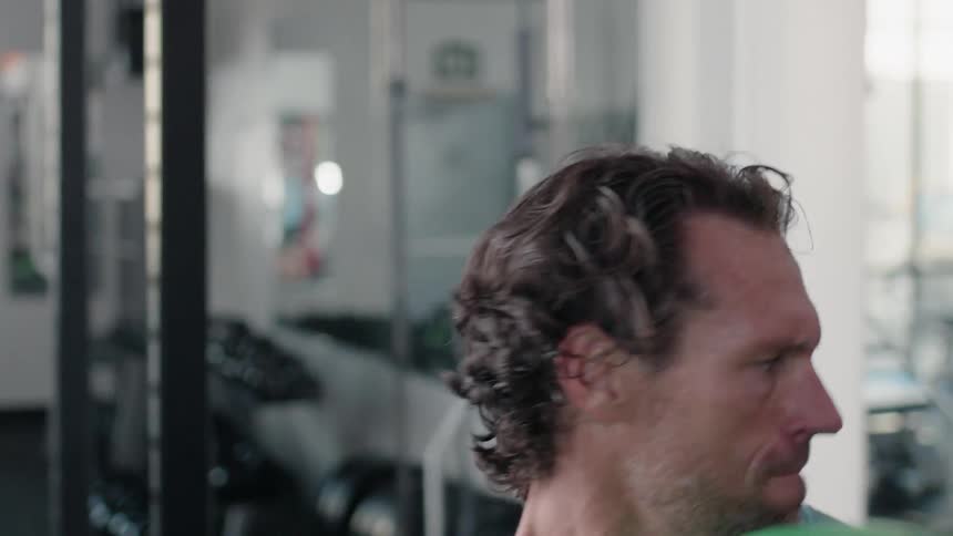 A man throws a medicine ball inside a gym