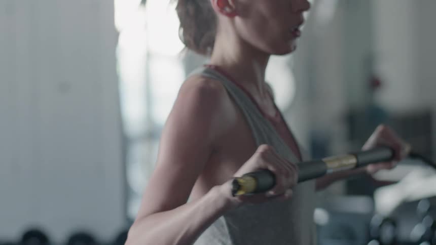Woman uses a bar to assist with exercising