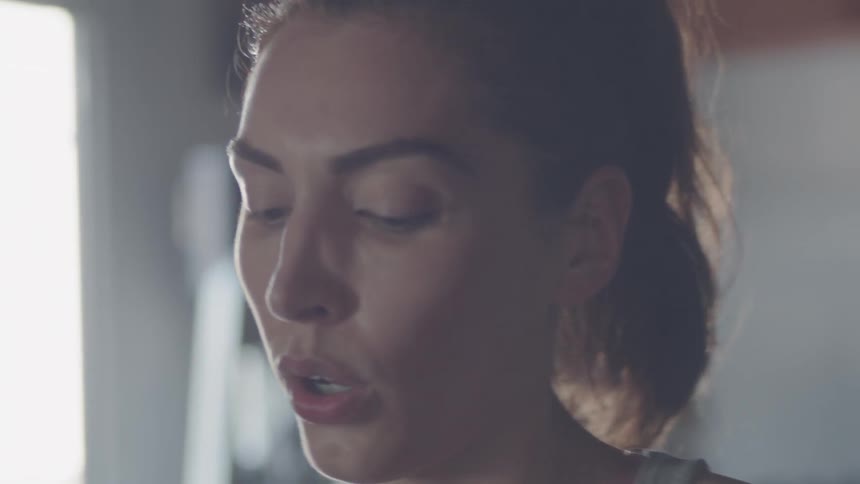 A woman with a ponytail breathes heavily