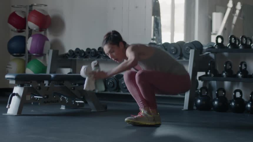 Woman gets up from the floor in a gym and walks away