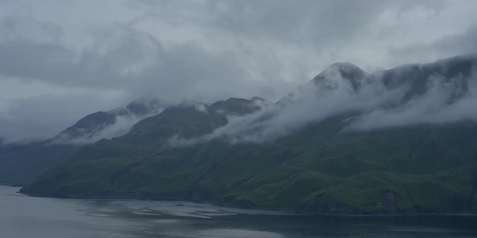 Clouds float over a mountain and bay