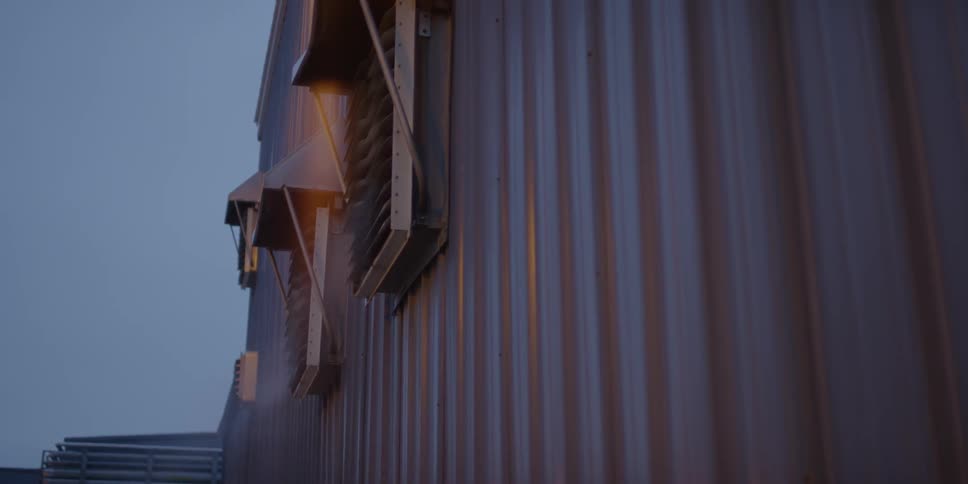 Steam pours from vents on the side of a metal building