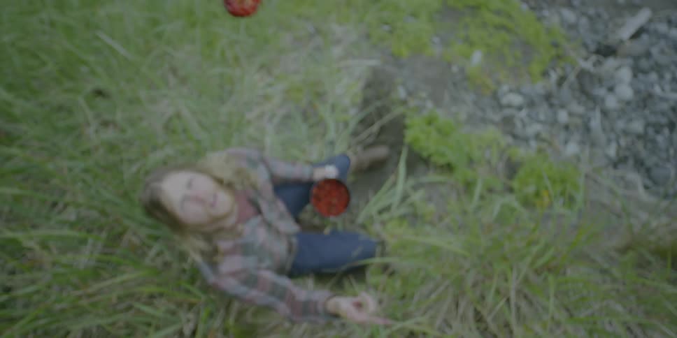 A man throws a berry into the air and catches it in his mouth