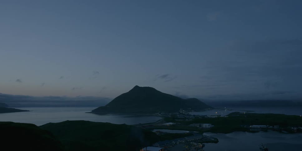 An island town with mountains at dusk