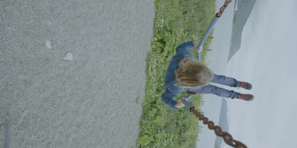Man plays on a swing next to ocean