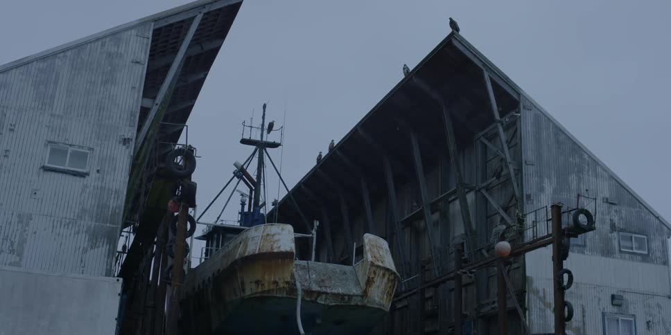 A rusty ship sits in a dry dock bay