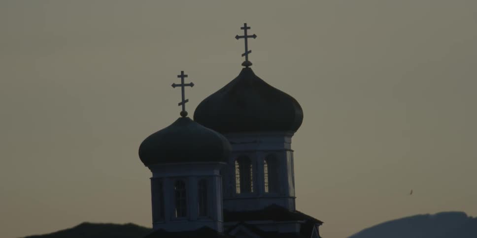 A domed church is shown at sunset