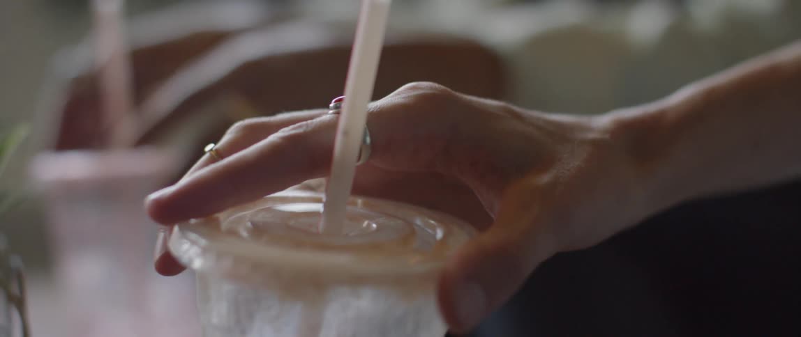 A woman holds a plastic cup and shakes it