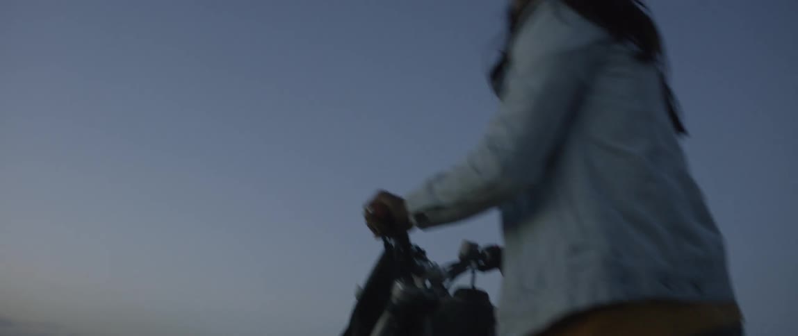 A man rides a dirt bike at dusk