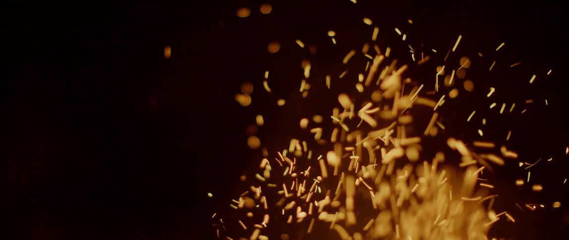 A fire burns outside at night