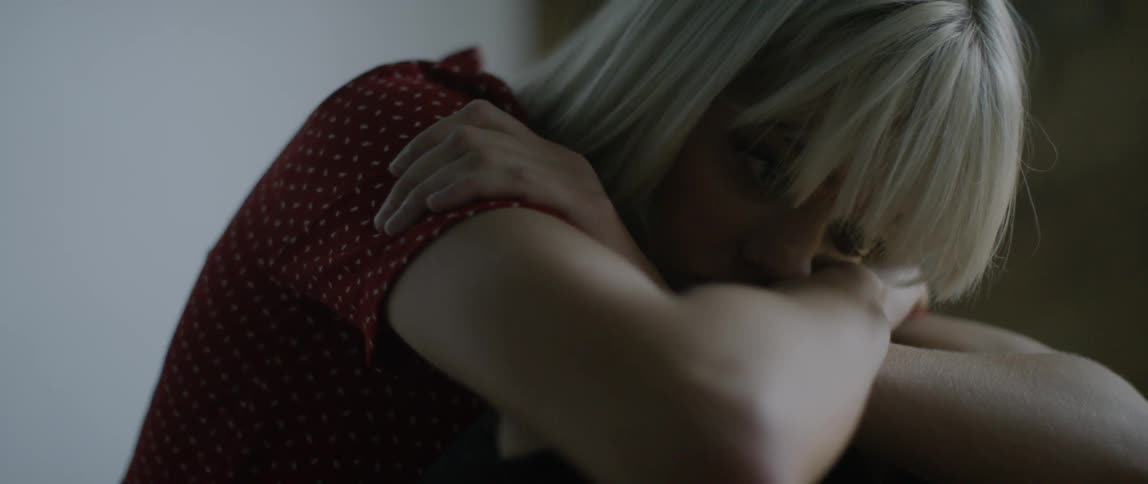 A sad looking woman rests her head in her arms