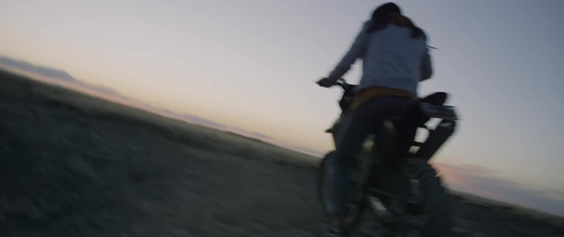 A man rides a dirt bike at dusk