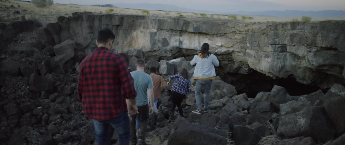 A group of people descend into a cave
