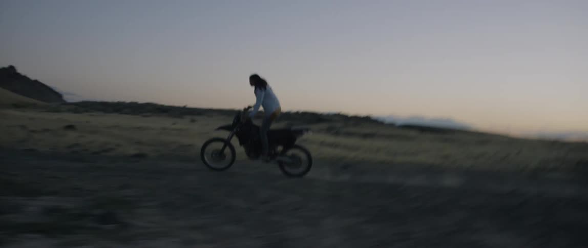 A man rides a dirt bike outside